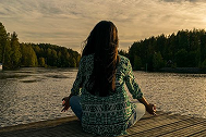 Lady doing yoga by the water. 